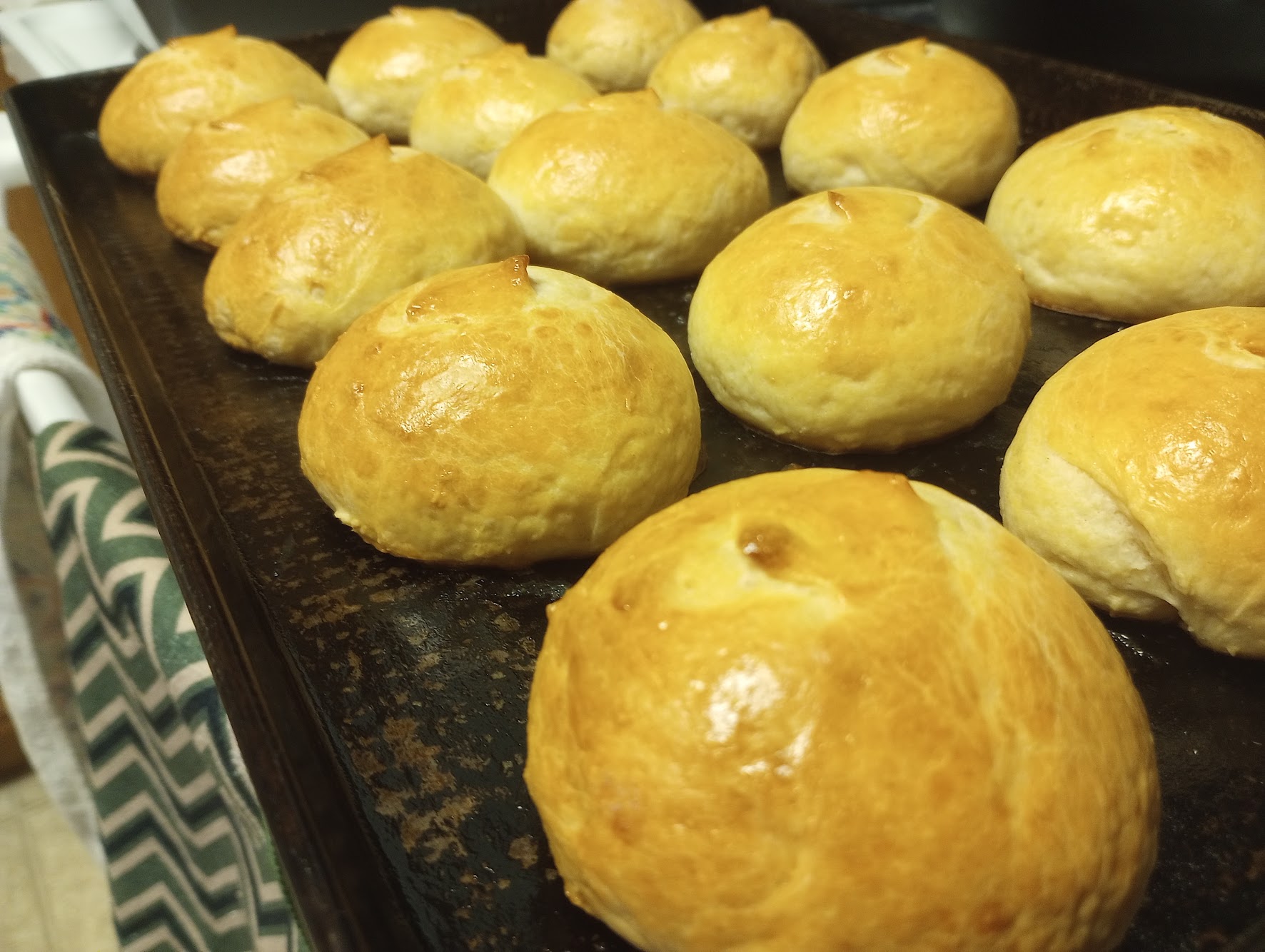 Golden artisan dinner rolls with glossy finish, freshly baked
